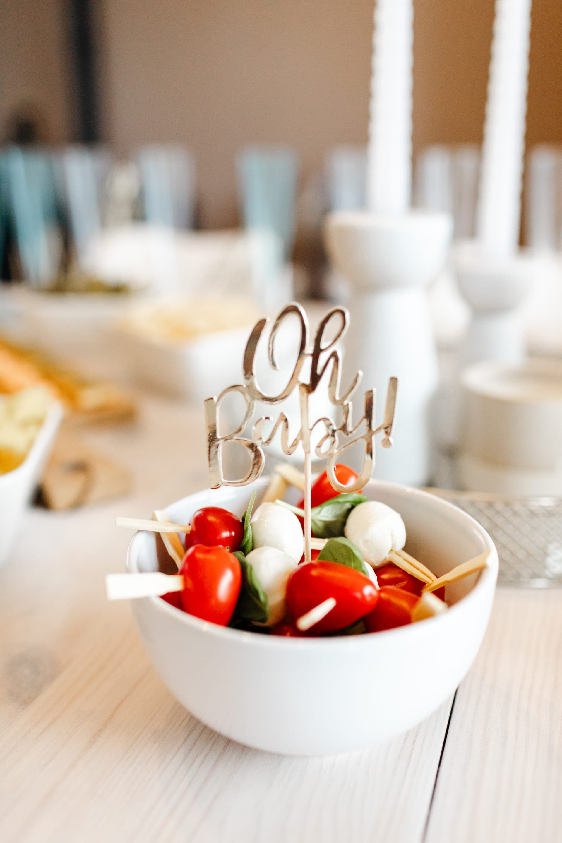 Détail buffet brochettes tomate mozzarella basilic dans un bol blanc avec topper doré Oh Baby — reportage baby shower décor gourmand Aurore Clercq Photographie