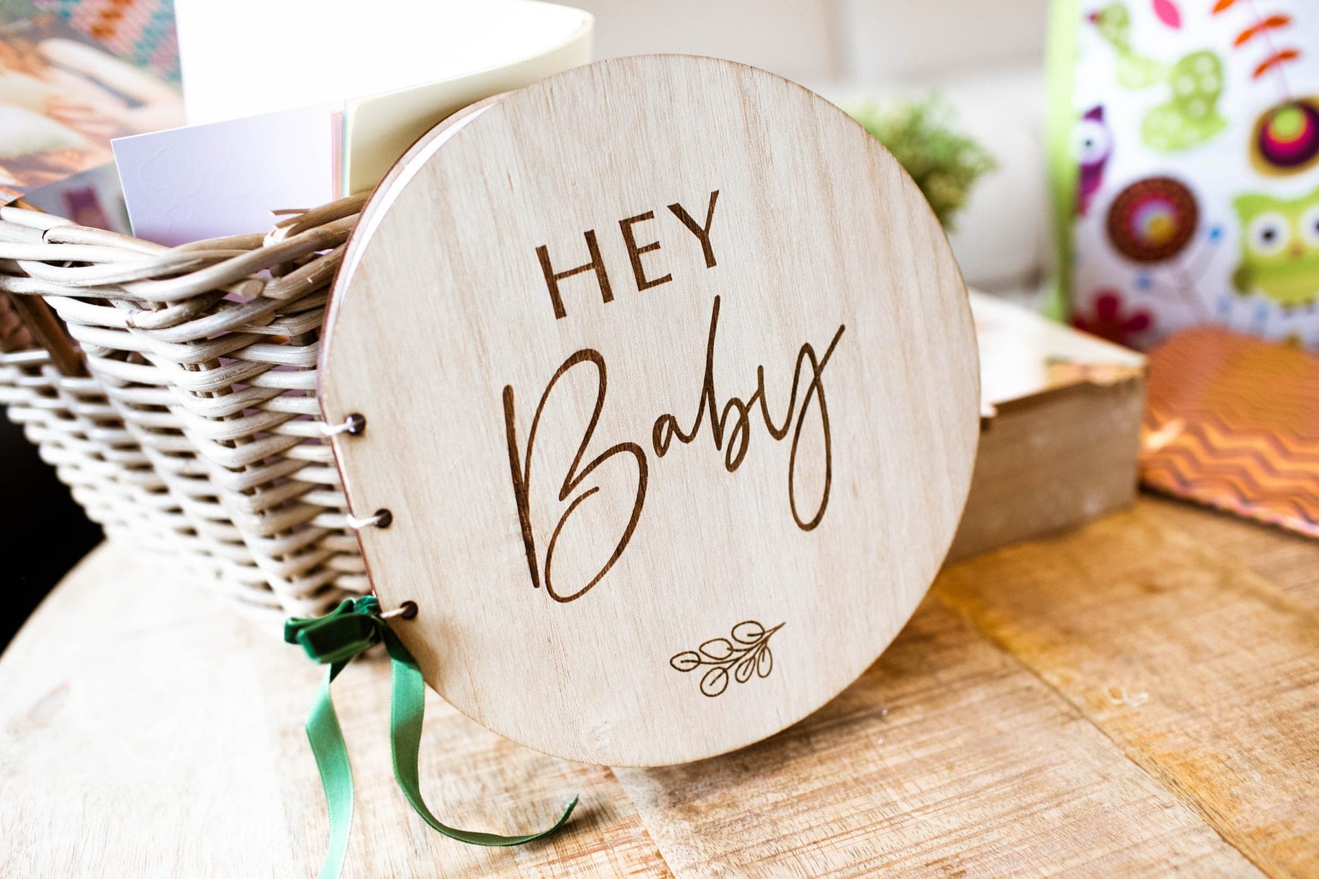 Détail décoratif d'un événement privé — livret souvenir en bois gravé « Hey Baby » lors d'une baby shower en Brabant Wallon