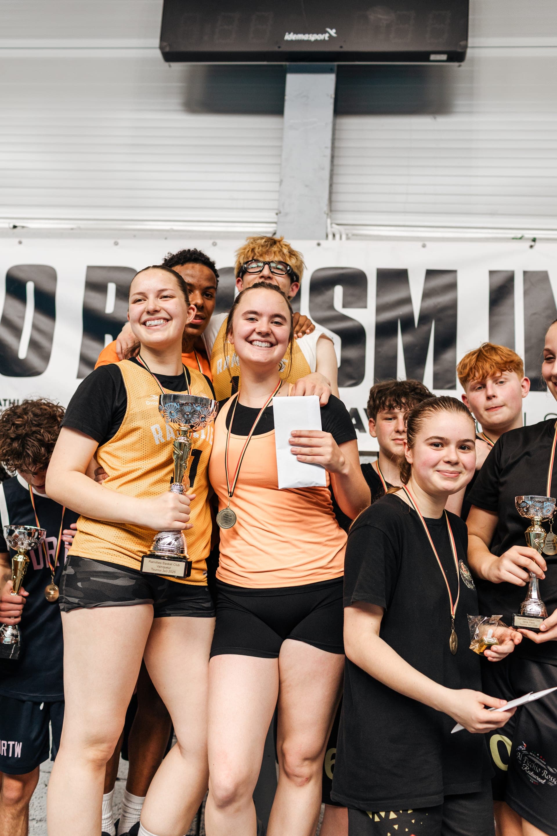 Équipe de jeunes joueurs souriants brandissant leurs trophées et médailles à la fin d'un tournoi — reportage photo d'événement sportif en Brabant Wallon