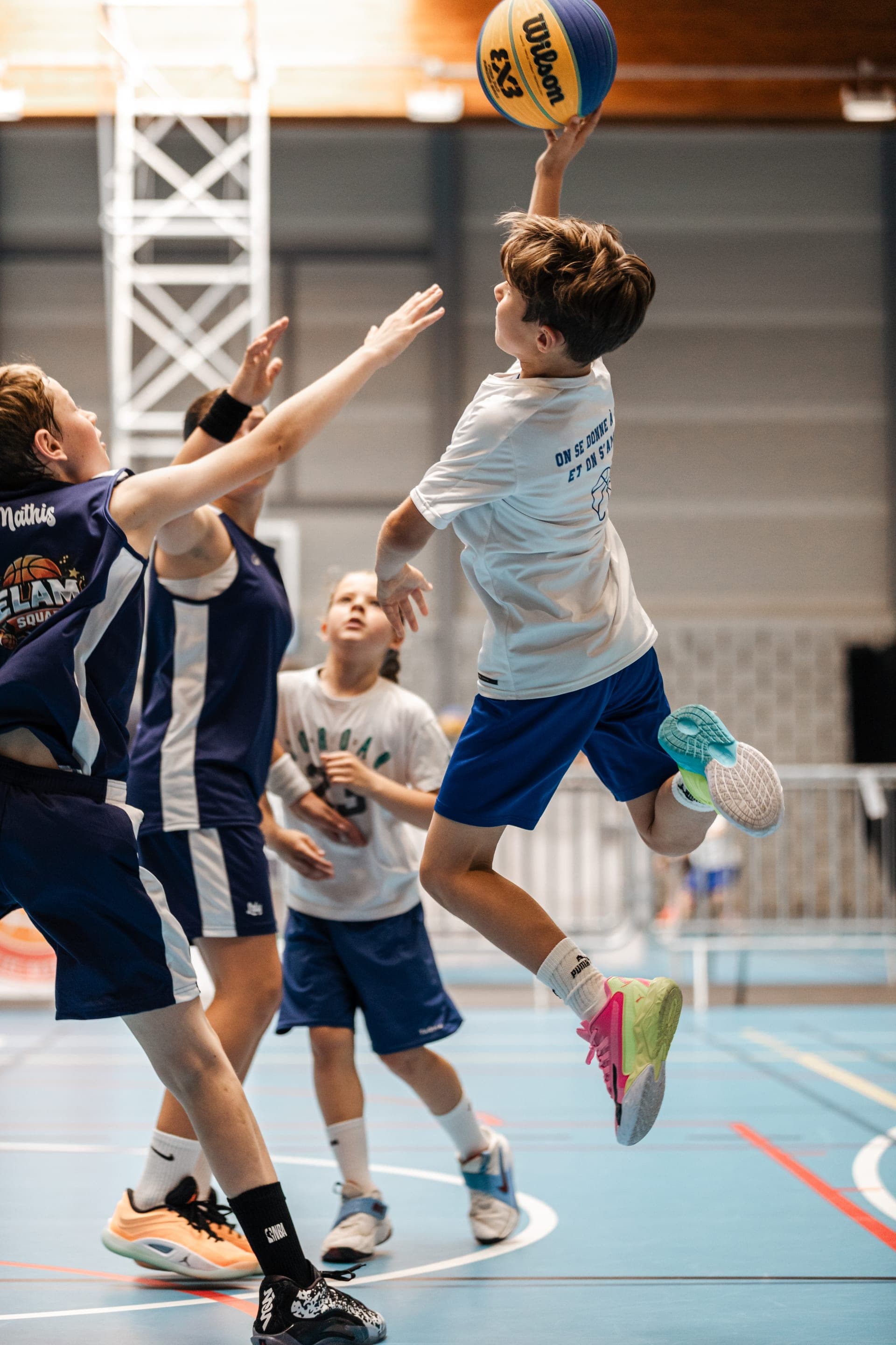 Jeunes joueurs en maillot dans un gymnase de stage de basket — reportage événement Brabant Wallon