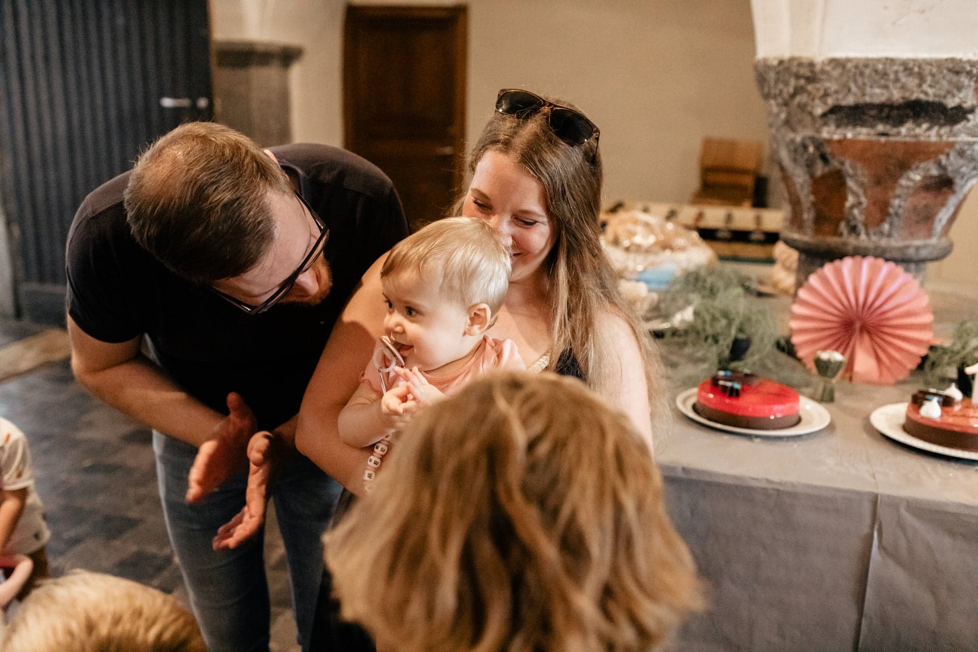 Parents tiennent leur bébé lors d'une réception avec gâteau — séance famille célébration
