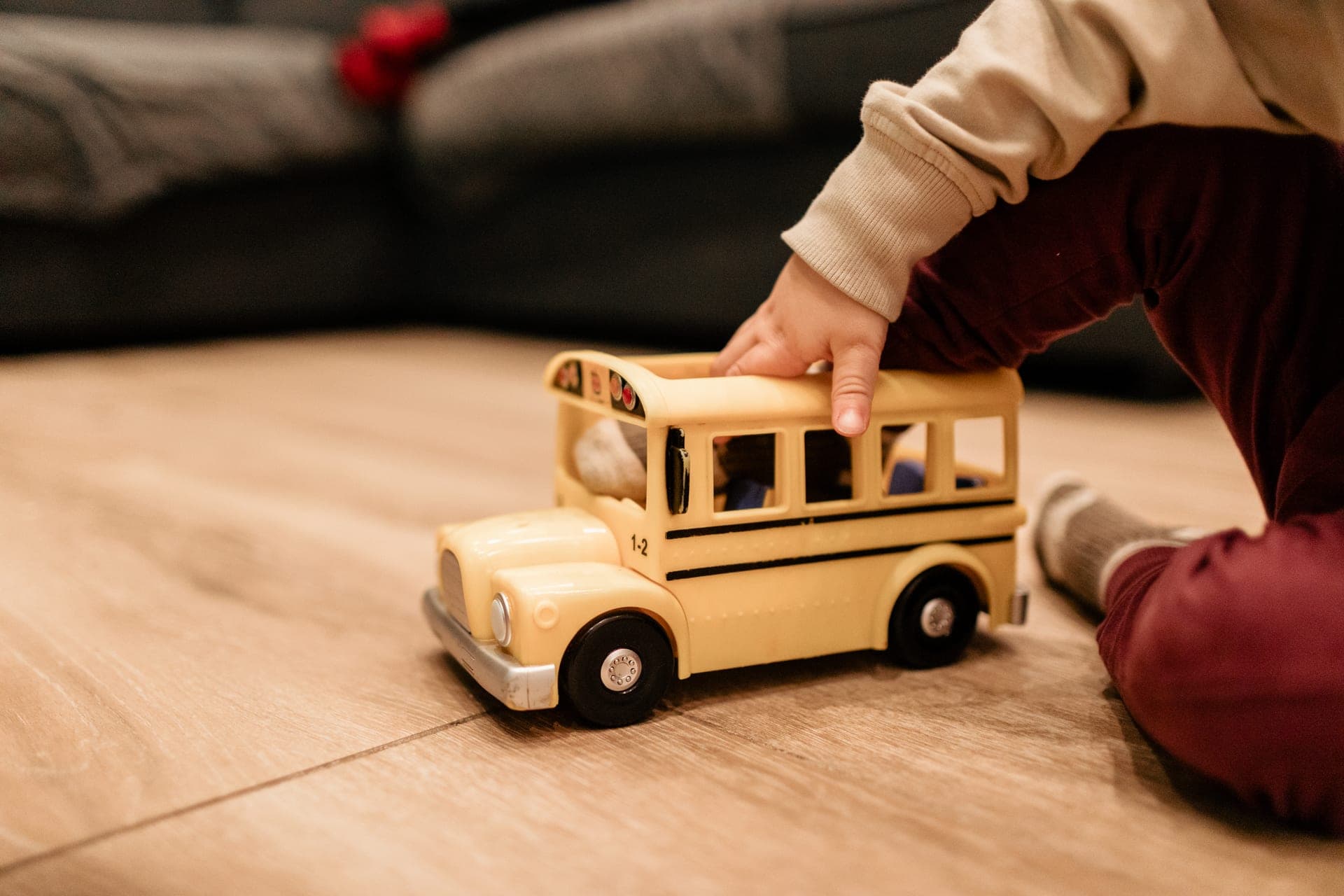 Détail bus en bois jouet vintage tenu par un enfant — séance famille enfance