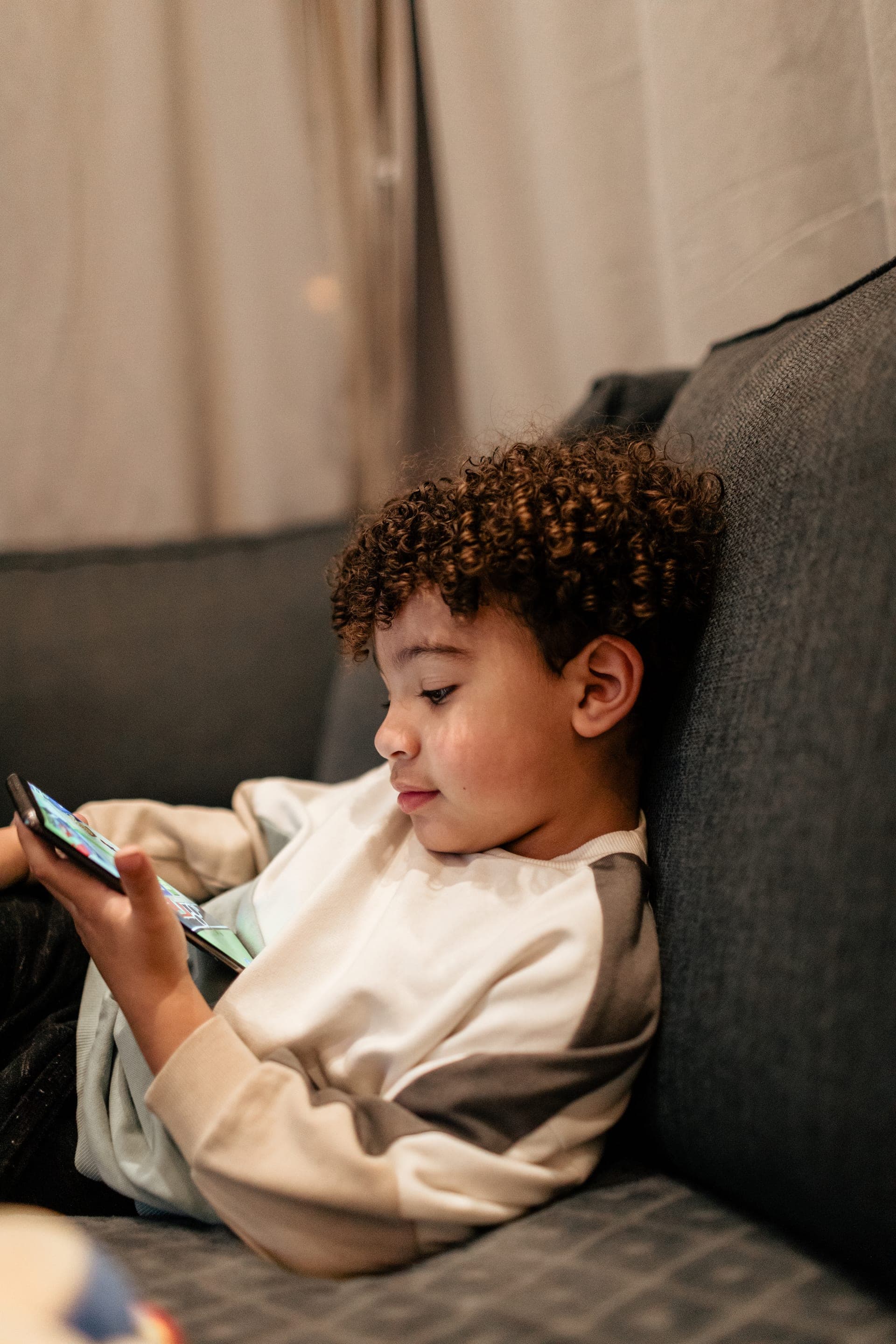 Enfant installé sur le canapé lifestyle à la maison — séance famille quotidien