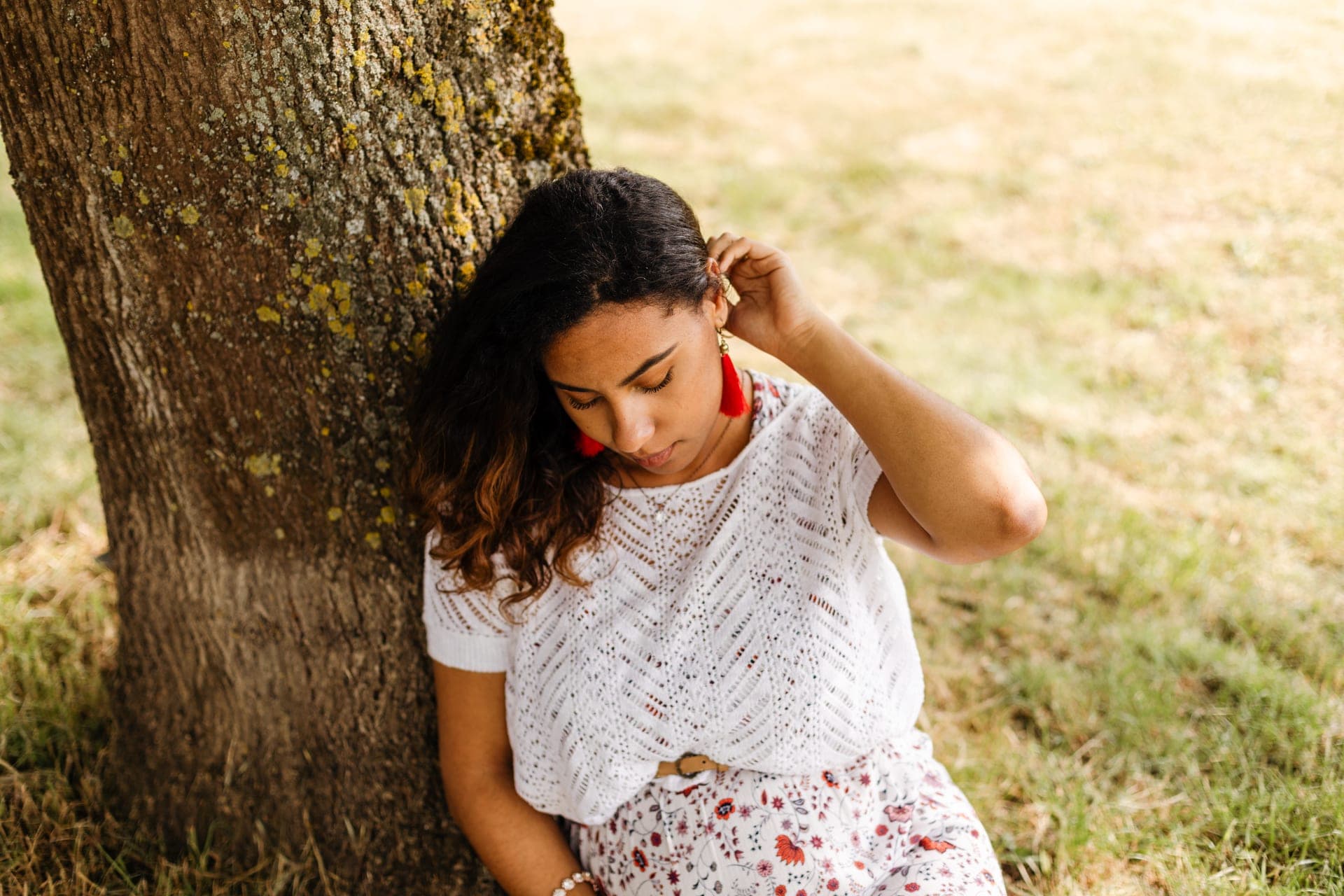 Future maman de profil contre un tronc d'arbre robe dentelle — séance grossesse douce