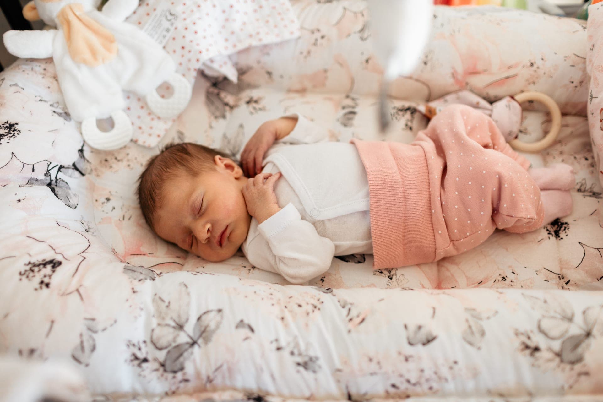 Nouveau-né endormi dans un cocon rose doux — séance naissance délicatesse