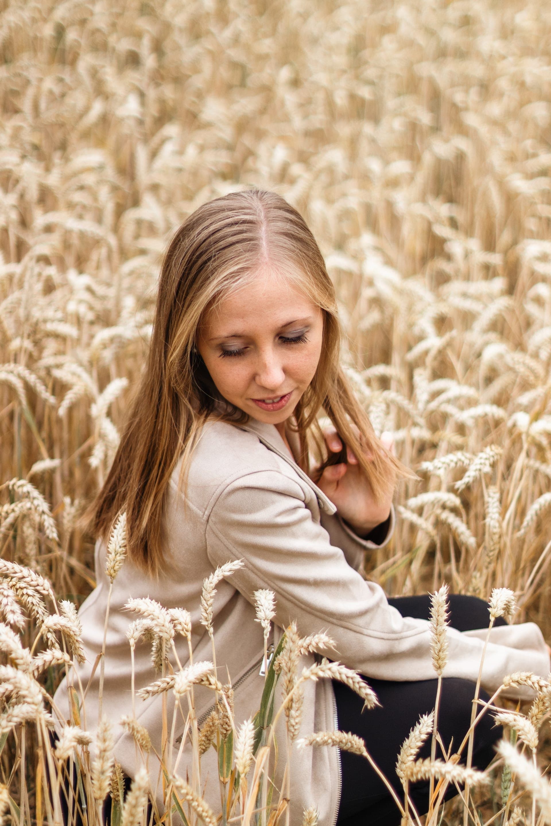 Portrait femme blonde profil dans un champ de blé manteau beige — séance portrait doré