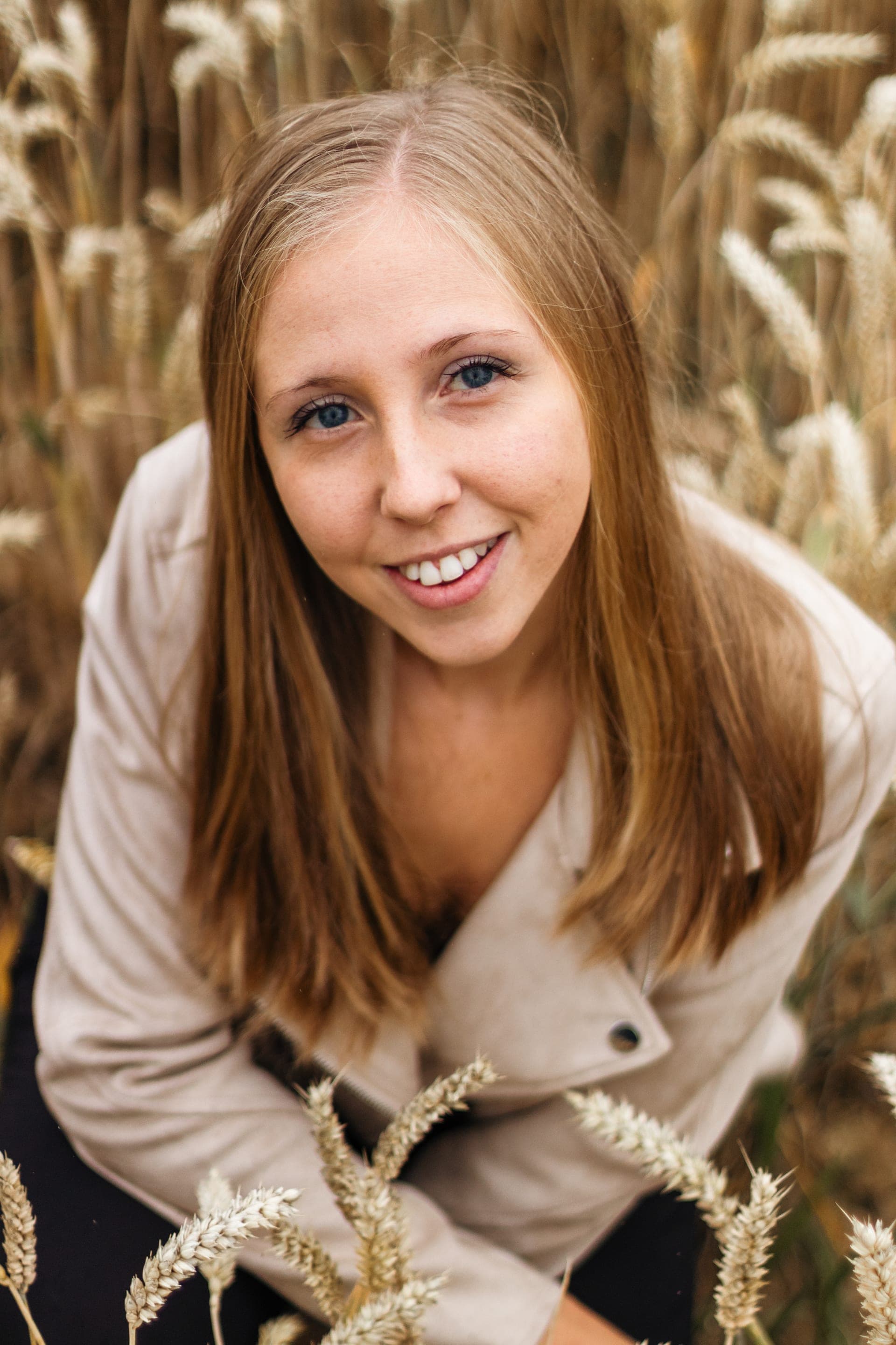 Portrait femme blonde sourire lumineux plongée champ de blé — séance portrait naturelle
