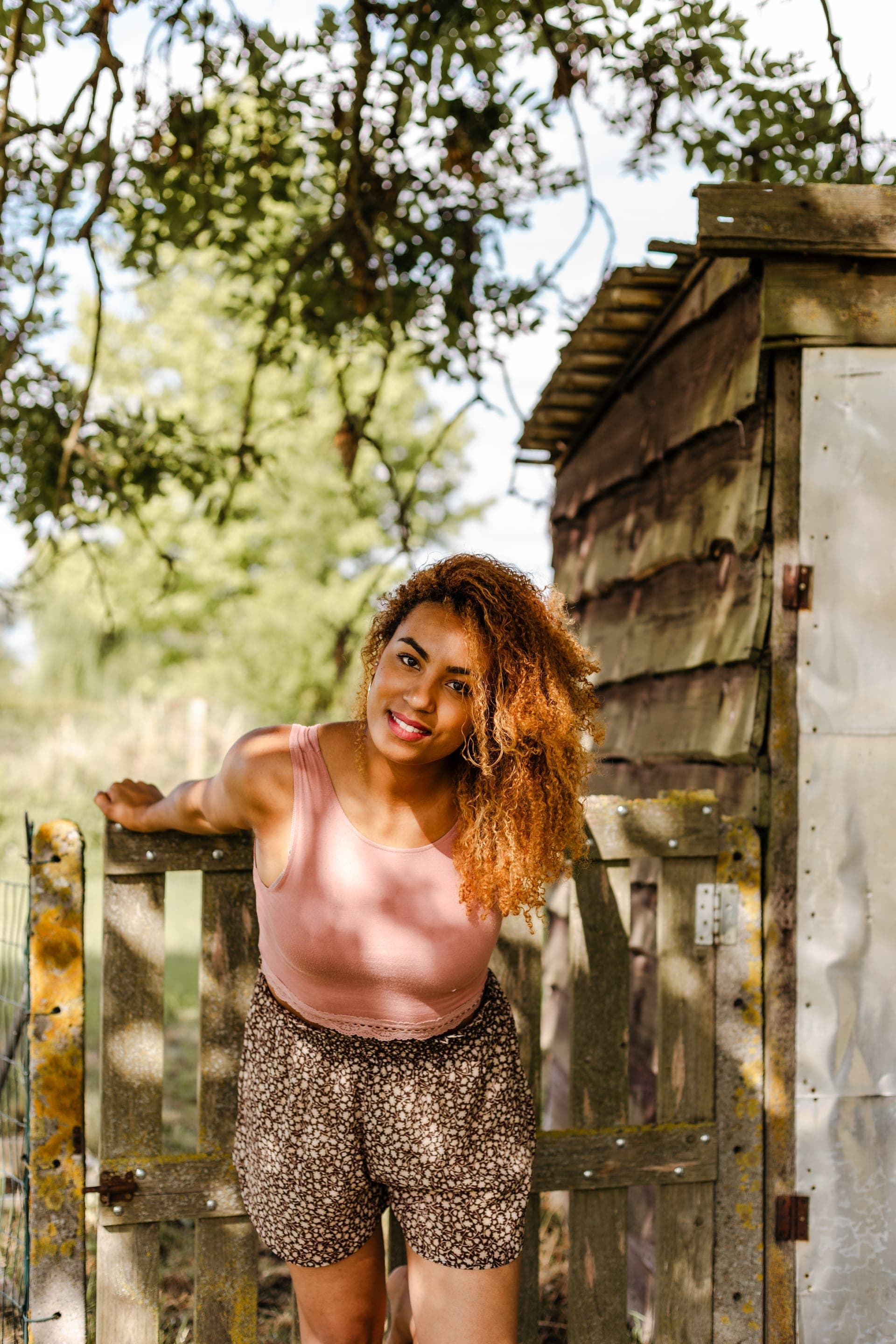 Portrait femme contre une porte en bois rustique sourire naturel — séance portrait lifestyle