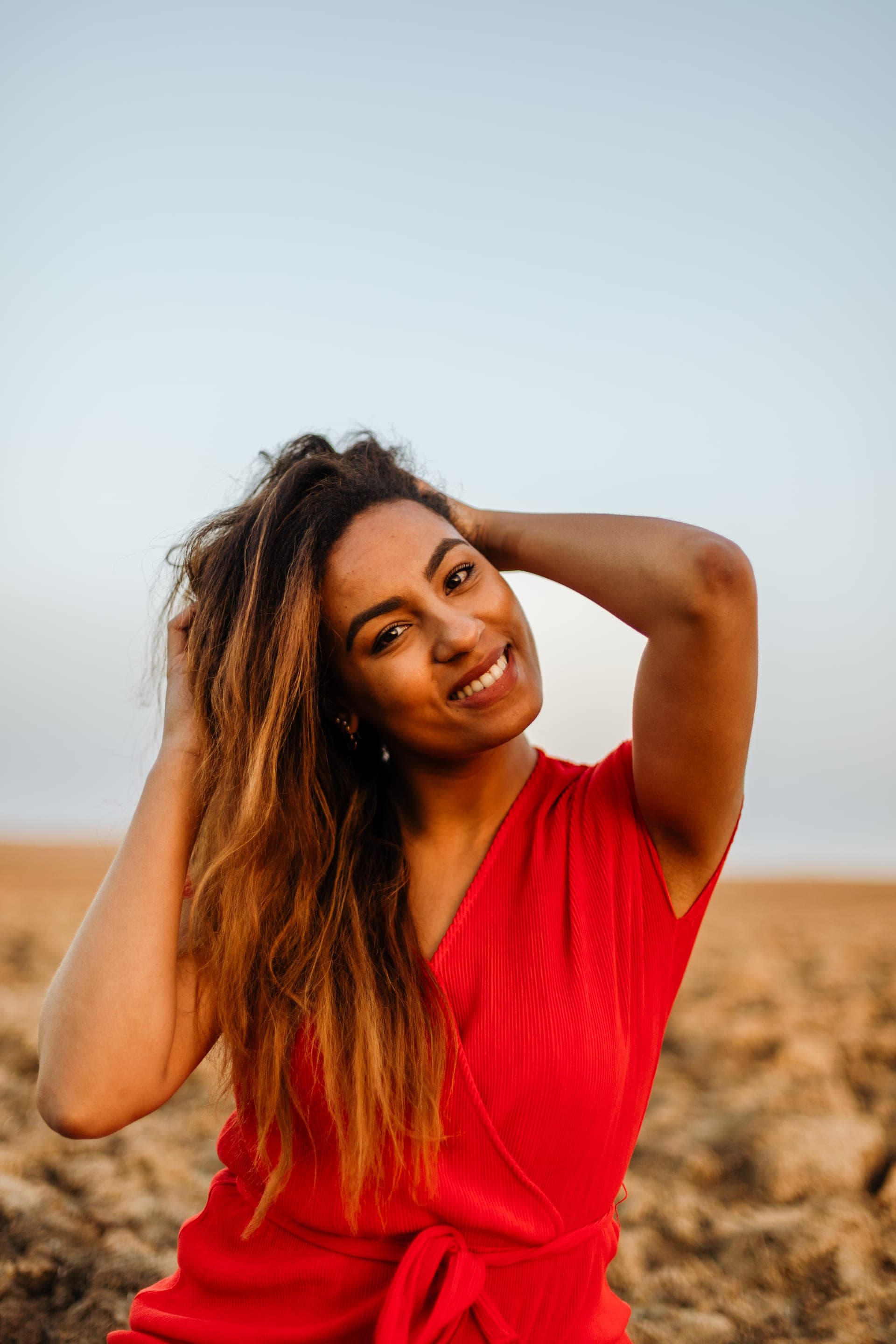 Portrait femme sourire lumineux dans un champ à l'horizon — séance portrait naturelle
