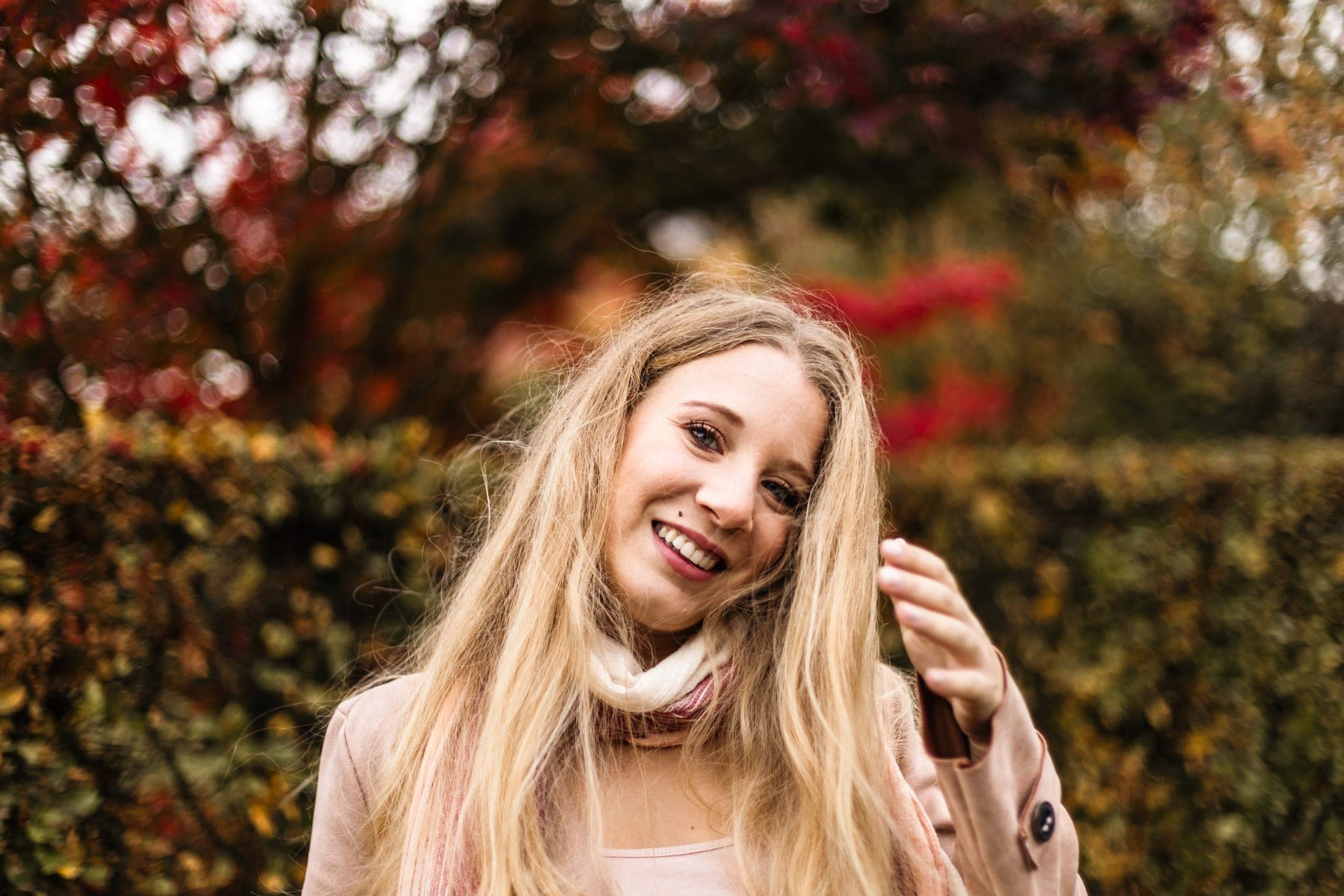 Portrait femme rire radieux manteau rose devant feuillage rouge en automne — Aurore Clercq Photographie Belgique
