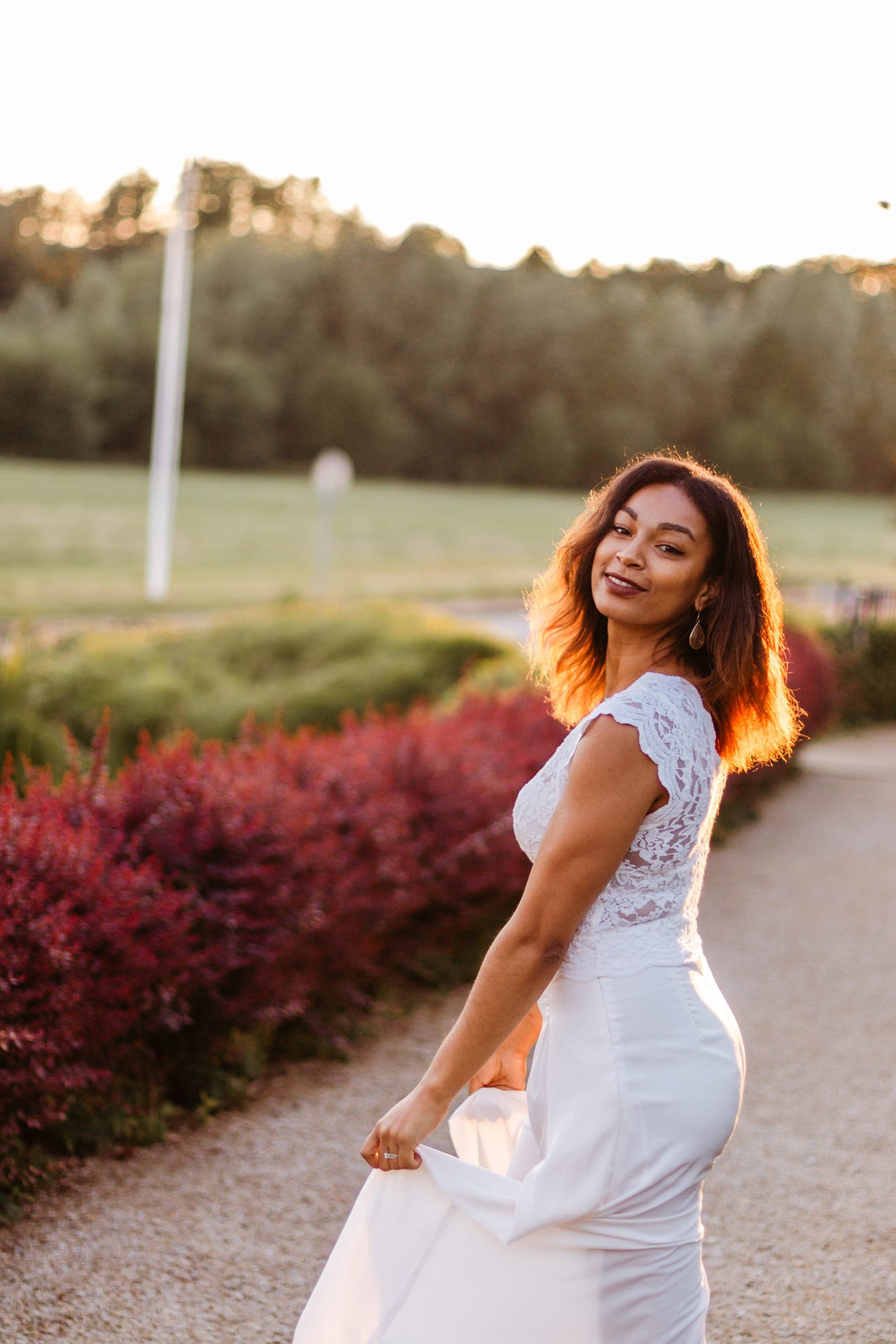 Portrait femme robe blanche marche sur un chemin au coucher du soleil — séance portrait poétique
