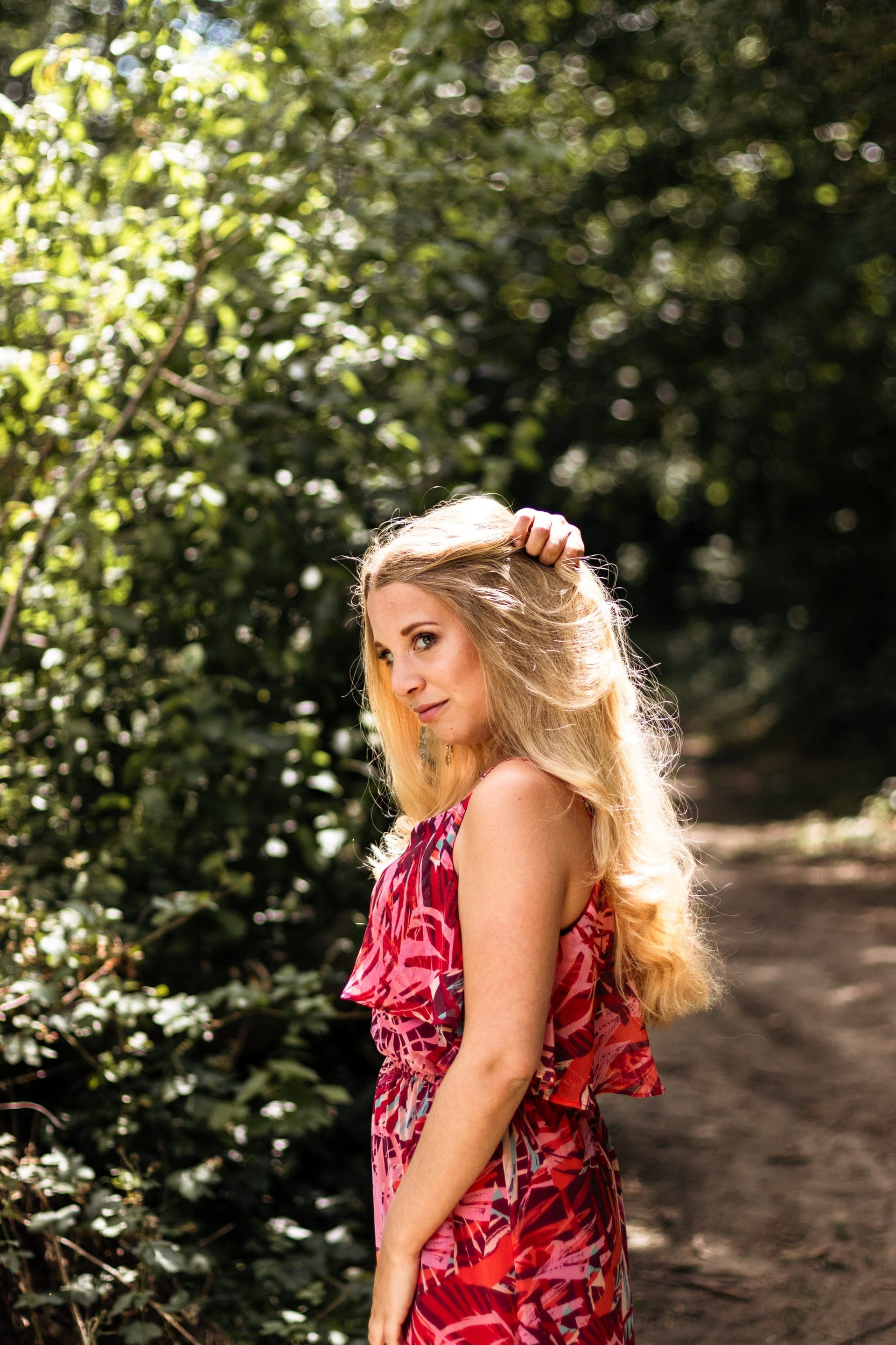Portrait femme robe rouge sur chemin de forêt regard caméra — Aurore Clercq Photographie Brabant Wallon