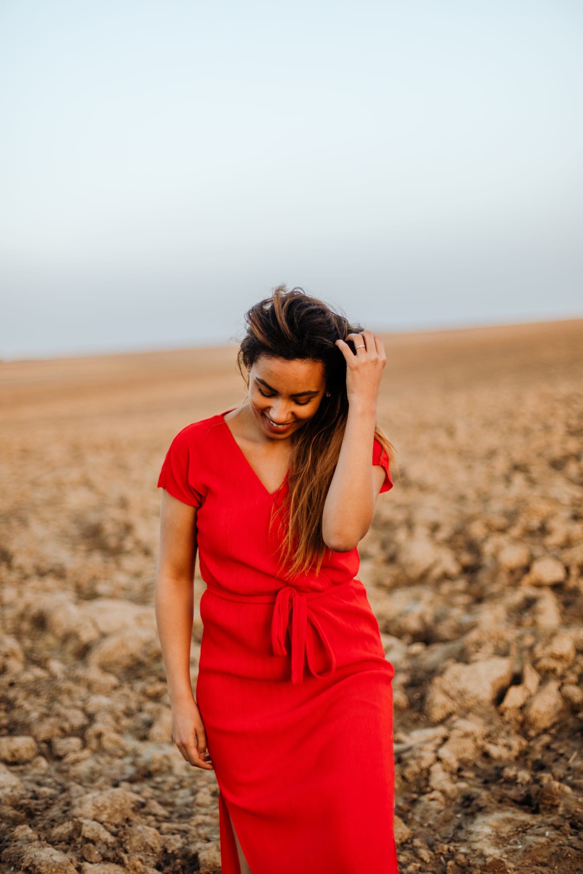 Portrait femme robe rouge profil mèche sourire campagne — séance portrait naturelle