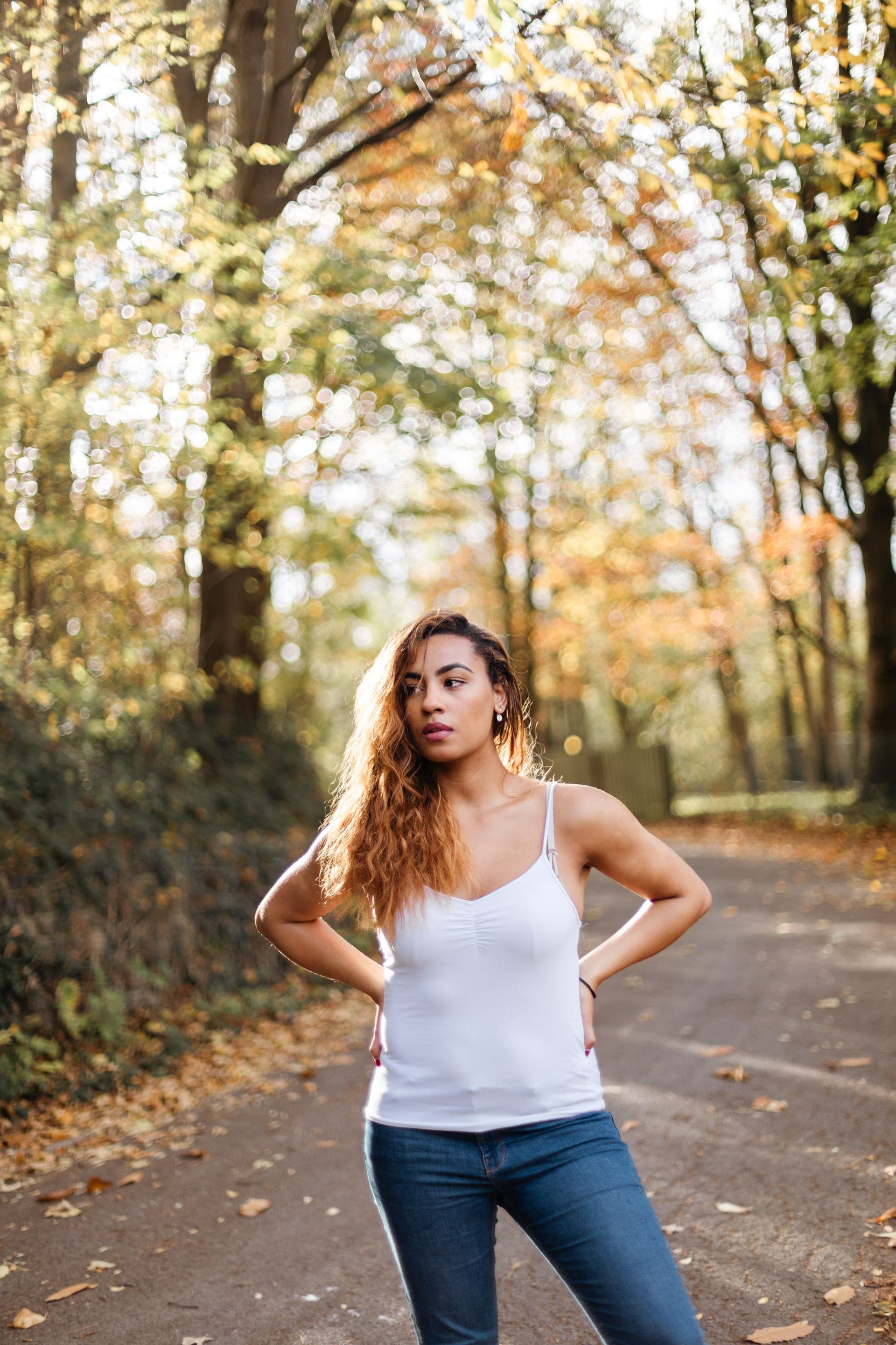 Portrait femme debout t-shirt blanc sur un chemin de forêt en automne — séance portrait nature